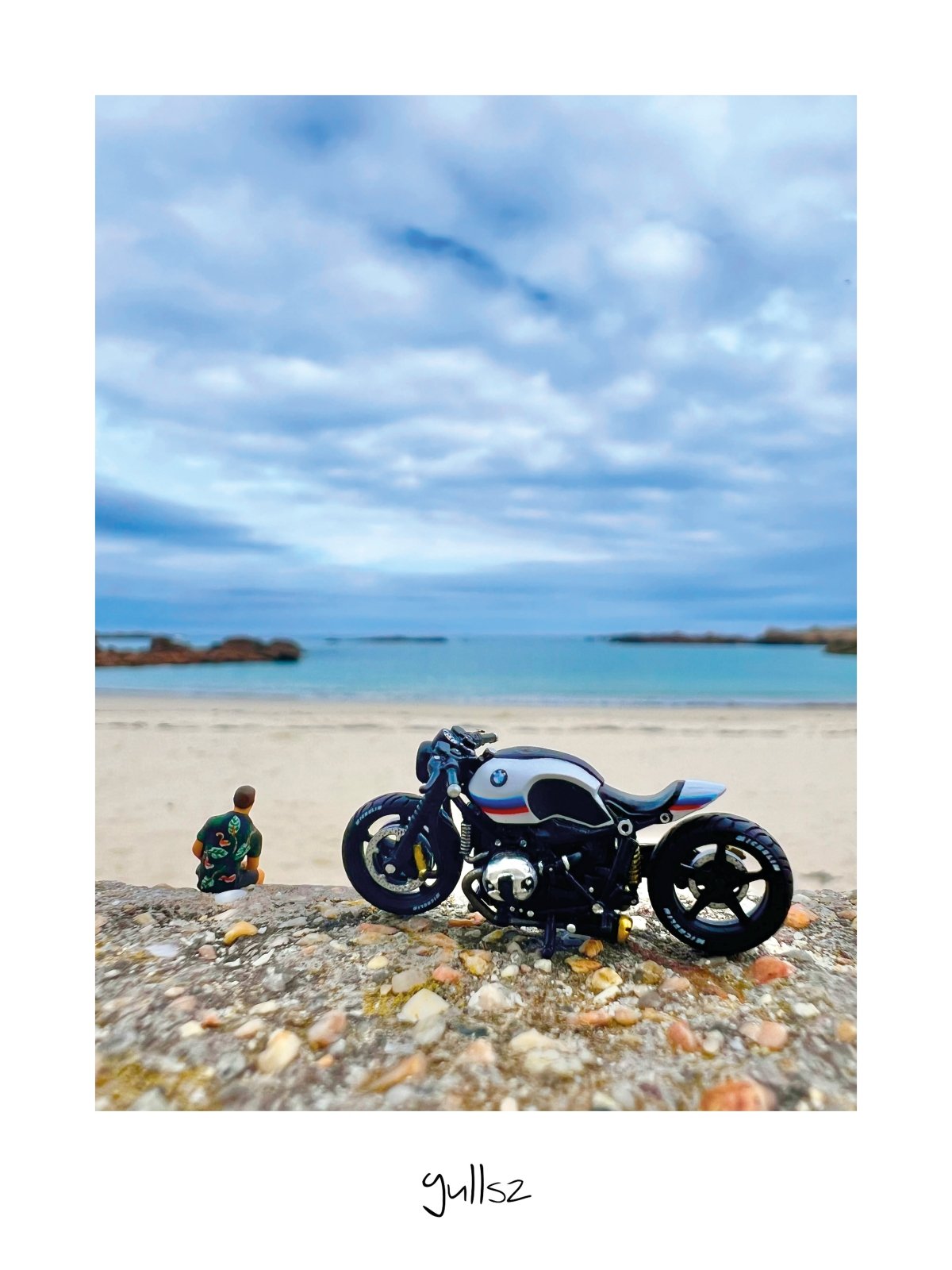 Photographie d'une moto garée face à la mer sur la Côte de Granit Rose à Trégastel.